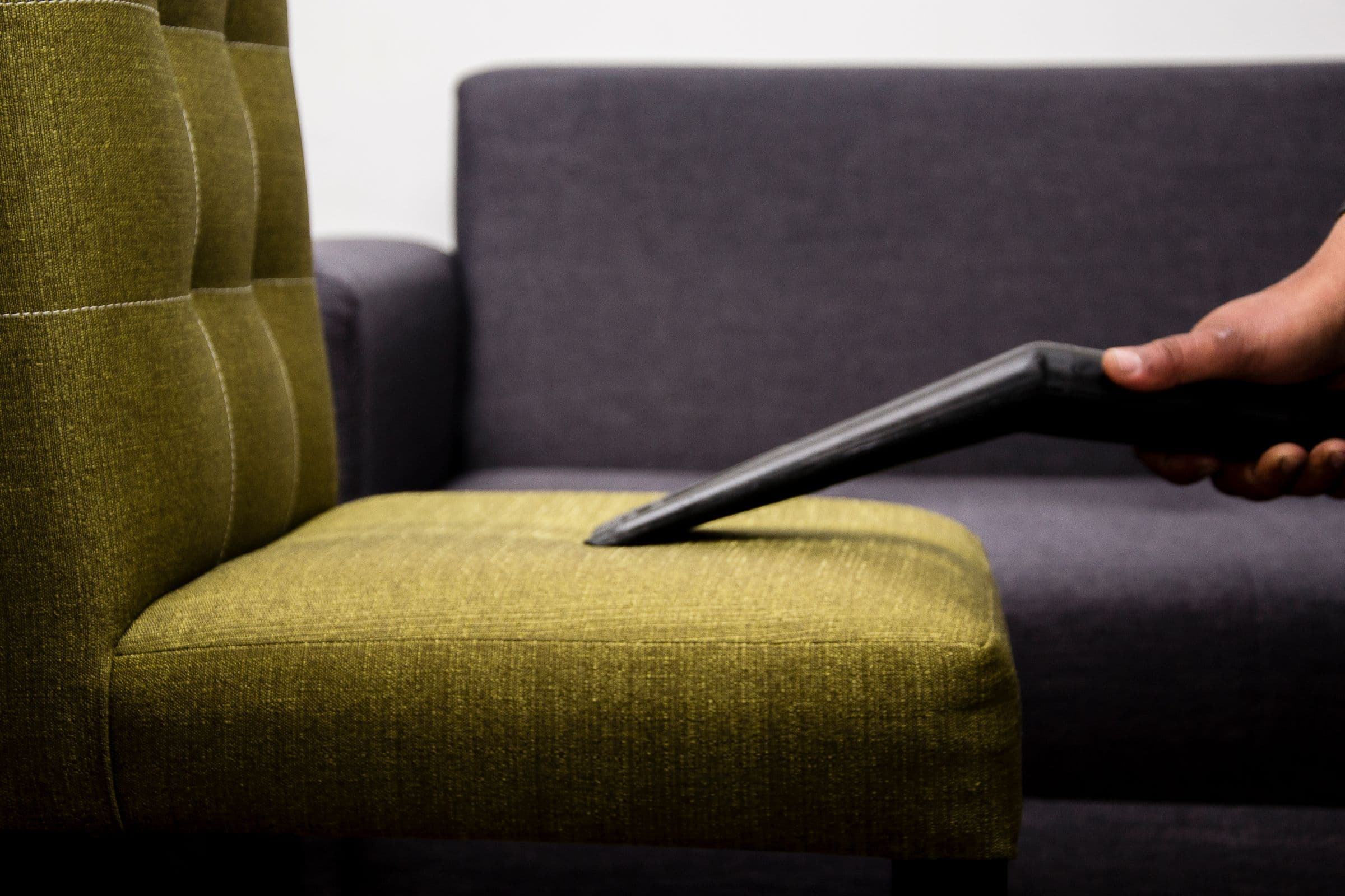 Fabric sofa being cleaned with an upholstery nozzle