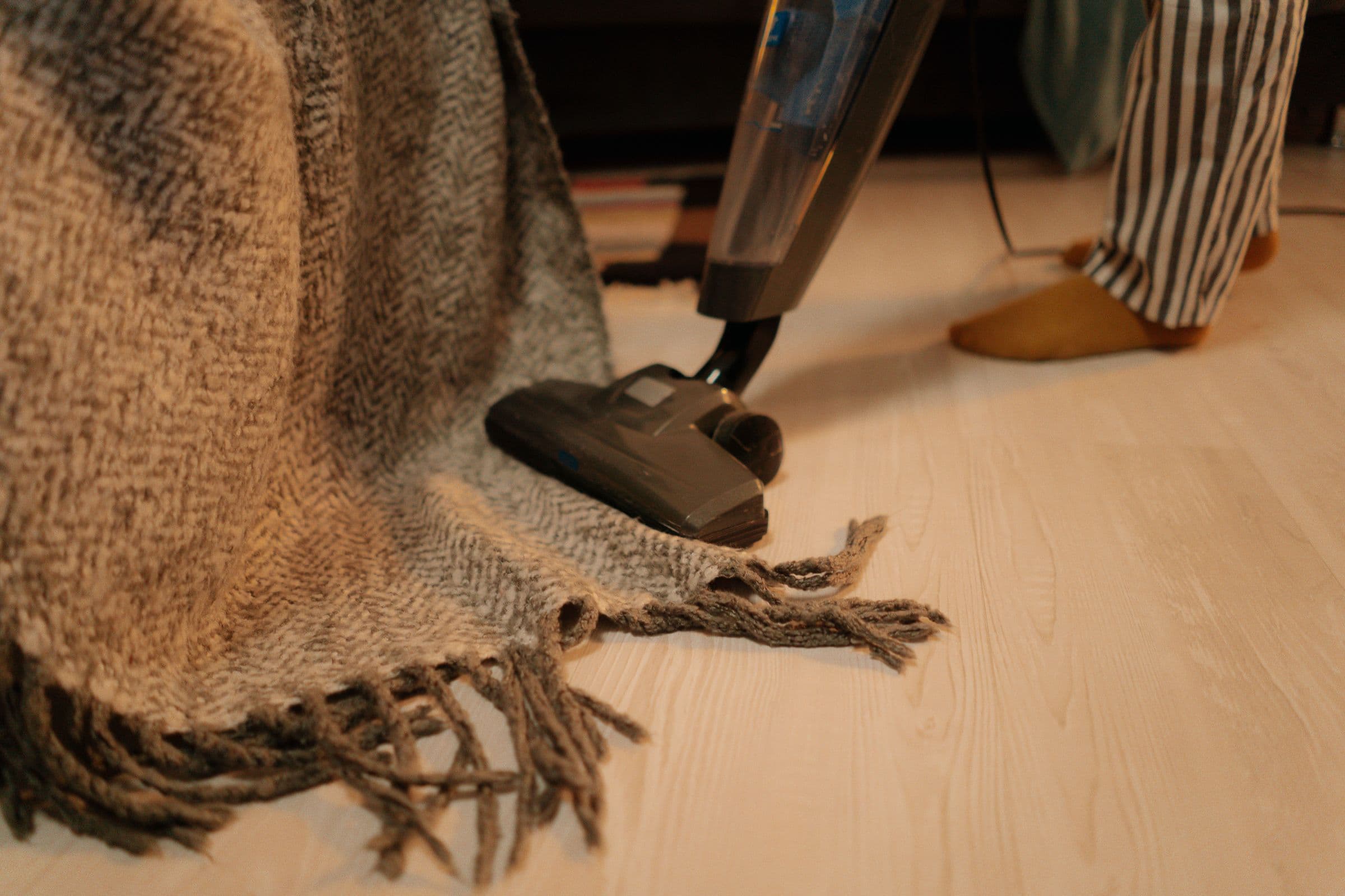 Rug being vacuumed on a light wooden floor