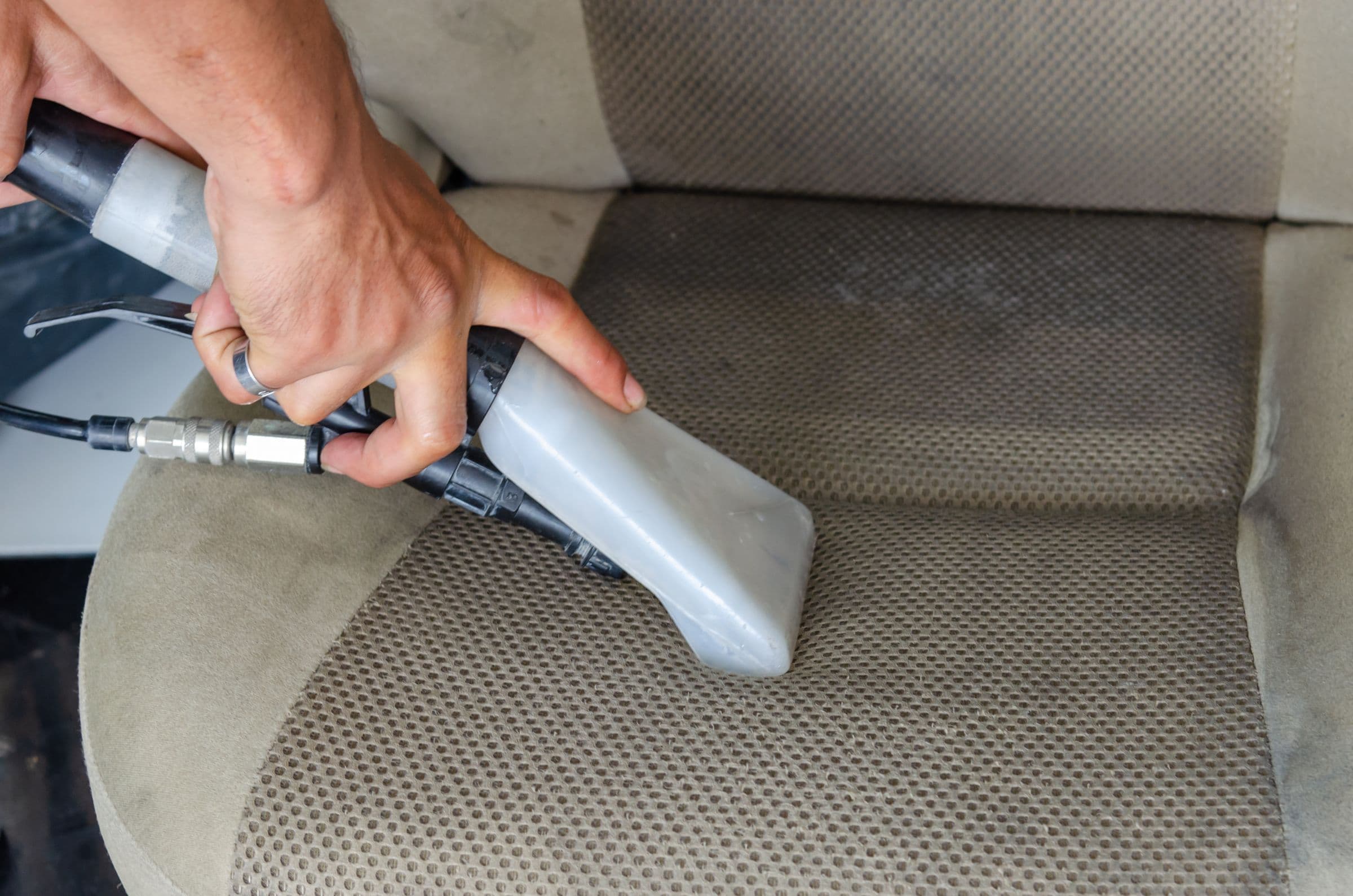 Fabric being cleaned with an extraction nozzle, showing a visible difference between clean and dirty